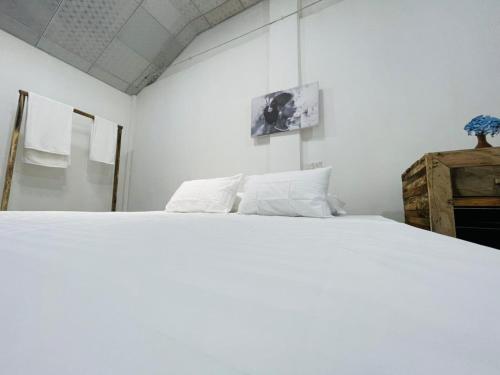 a white bed with white pillows in a room at Rani Homestay & Restaurant in Gampola