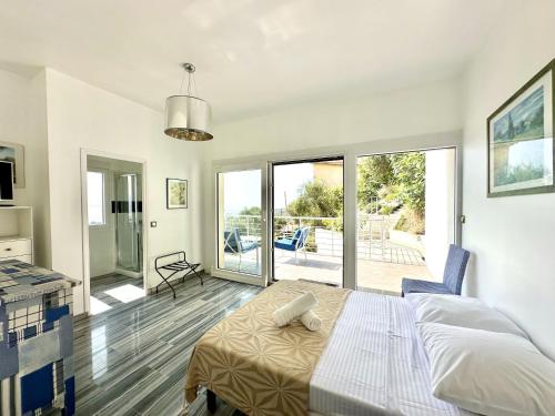 une chambre blanche avec un lit et un balcon dans l'établissement Villa Pessicart, à Nice