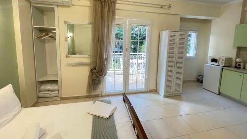 una cucina con tavolo, frigorifero e finestra di Orea Boutique Studios a Asprovalta