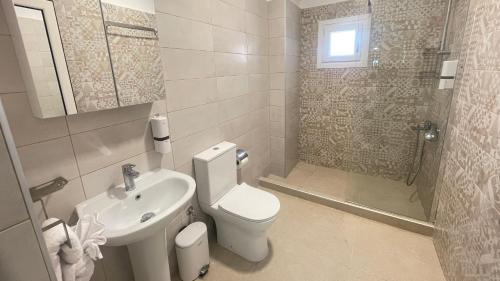 a bathroom with a toilet and a sink and a shower at Orea Boutique Studios in Asprovalta