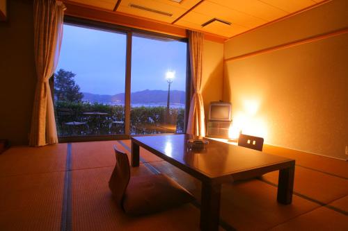 a living room with a table and a large window at Amanohashidateso in Miyazu