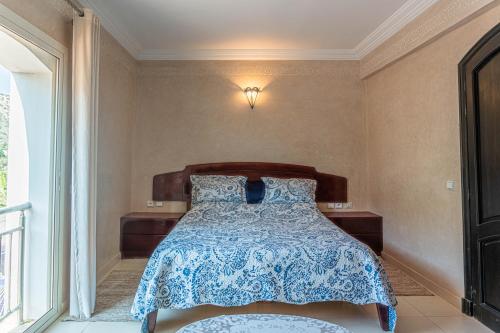 a bedroom with a bed with a blue and white bedspread at Luxury Villa Ocean View with pool in Tiguert