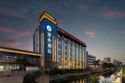 a building with a clock on the side of it at Changzhou Railway Station Qingguoxiang Manxin Hotel in Changzhou