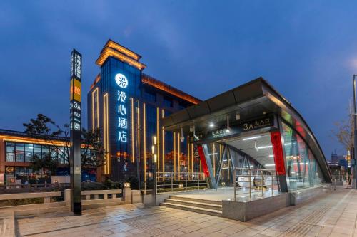 a building with a clock on the side of it at Changzhou Railway Station Qingguoxiang Manxin Hotel in Changzhou