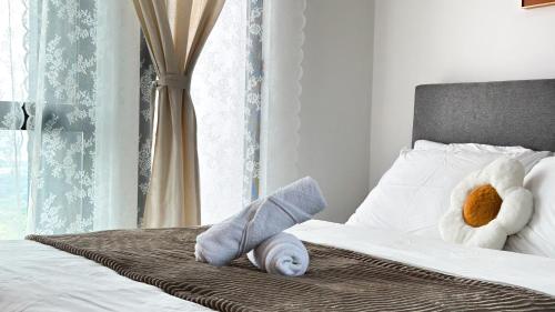 a stuffed animal is laying on a bed at Tulip Residences by Manhattan Group in Shah Alam