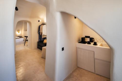 een hal met een witte kamer met een badkamer bij Calissa Suites by Ananda in Pirgos