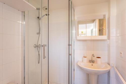 a white bathroom with a sink and a shower at Evasion à Vannes - Appartement sur le Port in Vannes