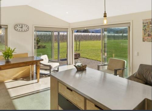a kitchen and living room with a table and chairs at Sun, Space, Cycle in Riwaka in Riwaka