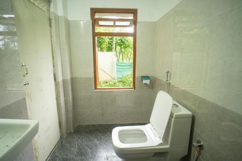 a bathroom with a toilet and a window at Keanas Lamahatta Homestay By StayApart in Takdāh