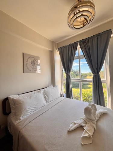 a bedroom with a bed with a large window at Twin AJ Boracay in Boracay
