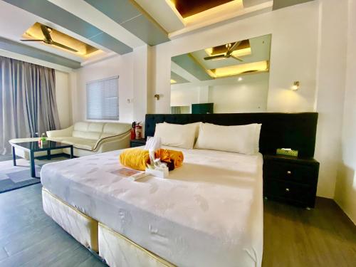 a bedroom with a large bed and a living room at Lalaguna Villas Luxury Dive Resort and Spa in Puerto Galera