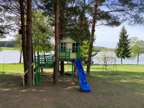 a playground with a slide and a tree at Našio kempingas in Antanaše