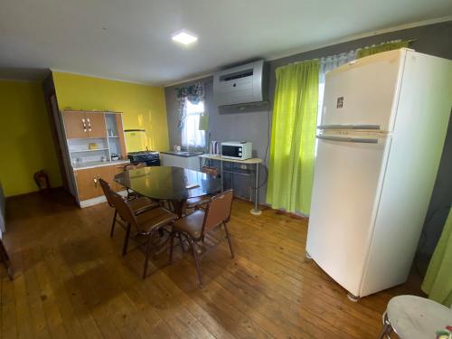 a kitchen with a table and a white refrigerator at Rancho Benjamín Salazar in San Clemente
