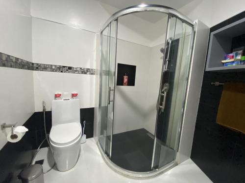 a bathroom with a toilet and a glass shower at Lalaguna Villas Luxury Dive Resort and Spa in Puerto Galera