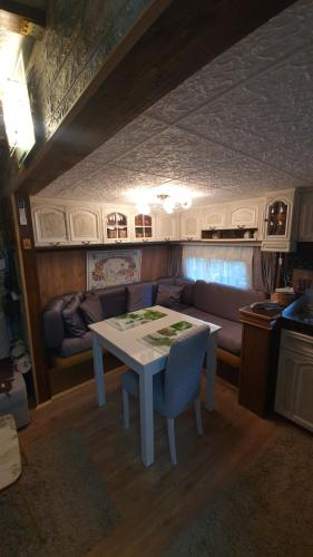 a living room with a table and a couch at Zlatiborska Brvnara Rebic Mountain House in Zlatibor