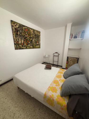 une chambre avec un lit et un tableau au mur dans l'établissement Appartement centre historique, à Beaucaire