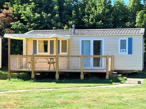 a tiny house with a porch and a deck at Aux Portes des Monts d'Aubrac in Espalion