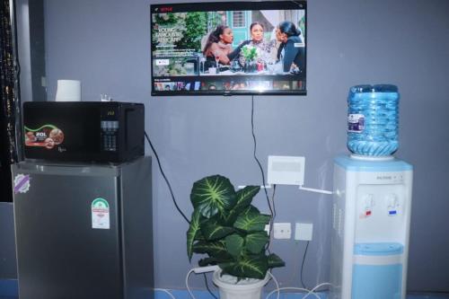 a tv hanging on a wall next to a refrigerator at The Loft & Found in Nairobi
