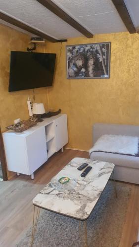 a living room with a tv and a coffee table at Zlatiborska Brvnara Rebic Mountain House in Zlatibor