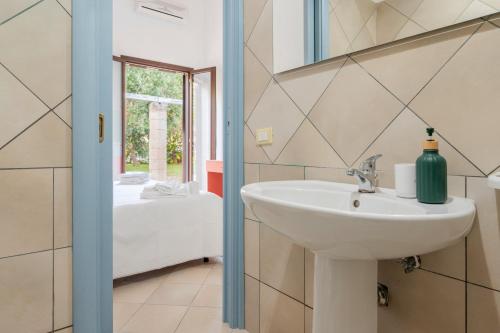 Un baño con lavabo y un dormitorio. en Il Giardino Dei Gelsi Otranto, en Otranto
