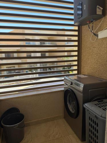 a washer and dryer in a room with a window at Appartement de très haut Standing à la Marina de Saïdia Résidence TAMARIS 6 piscine VIP in Saidia 