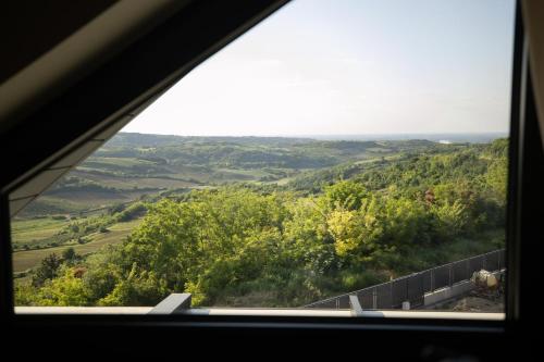 a view of a valley from a window at Pećina Stroga - Bjelica Winery Rooms in Sremski Karlovci