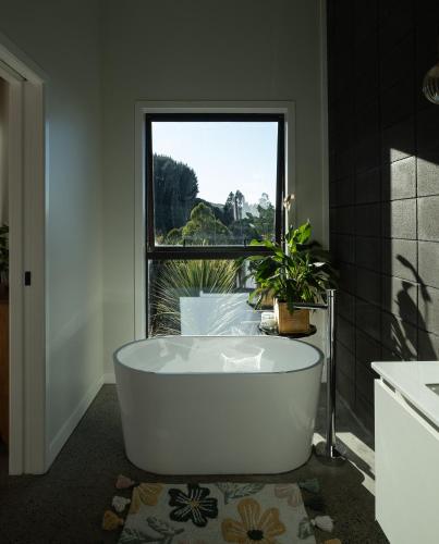 a bath tub in a bathroom with a window at Manu Heights Retreat, tranquil luxury, views and privacy in Dunedin