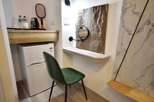 a green chair in a bathroom with a mirror at 知本溫泉-彩溱旅宿 in Wenquan