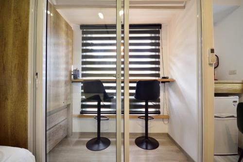 a bedroom with a desk and two chairs in front of a window at 知本溫泉-彩溱旅宿 in Wenquan