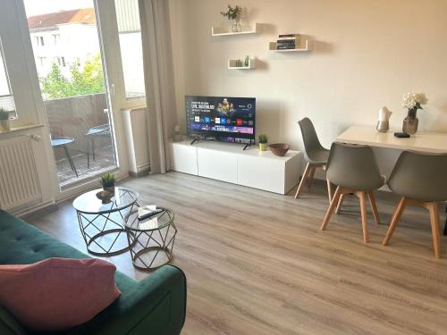 a living room with a couch and a table and a tv at GÖH-moderne Wohnung in zentraler Lage, Balkon, self-check-in, WLAN, Netflix, DisneyPlus in Hannover