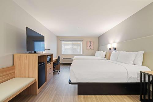 a hotel room with two beds and a flat screen tv at Best Western Lake Oswego Hotel & Suites in Lake Oswego