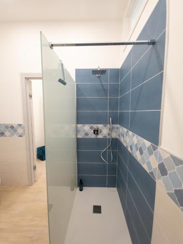 a bathroom with a shower with blue tiles at Light Charme, Sea Light Apartment a due passi dalla PIAZZA DUOMO in Terrasini