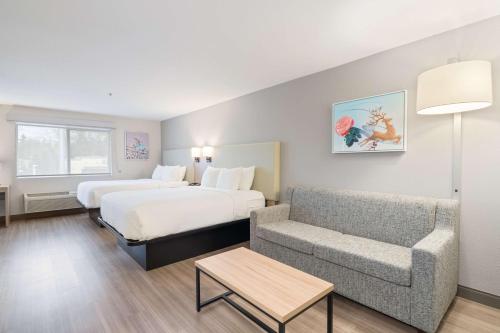 a hotel room with a bed and a couch at Best Western Lake Oswego Hotel & Suites in Lake Oswego