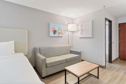 a bedroom with a bed and a couch and a chair at Best Western Lake Oswego Hotel & Suites in Lake Oswego