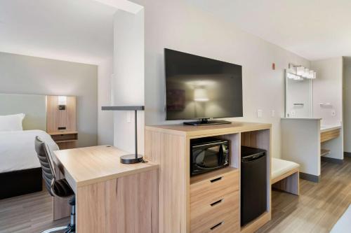 a hotel room with a flat screen tv and a bed at Best Western Lake Oswego Hotel & Suites in Lake Oswego