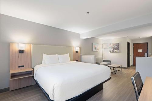a large white bed in a hotel room at Best Western Lake Oswego Hotel & Suites in Lake Oswego