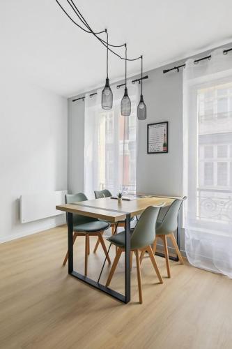 une salle à manger avec une table et des chaises dans l'établissement le SPARN - Votre cocon au coeur d'Epernay, à Épernay