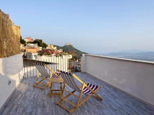 two chairs on a balcony with a view of the ocean at Monte Longu in Baunei