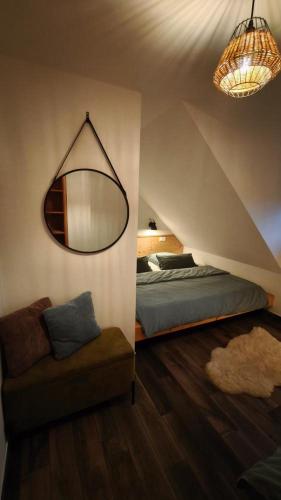 a bedroom with a bed and a mirror and a couch at CHALUPA U ROUBÍČKŮ in Horní Bečva