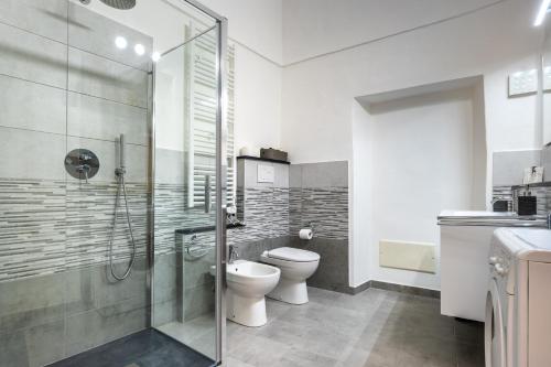 a bathroom with a toilet and a glass shower at Hostdomus-Country House in Orco Feglino