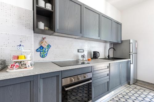 a kitchen with gray cabinets and a sink at Hostdomus-Country House in Orco Feglino