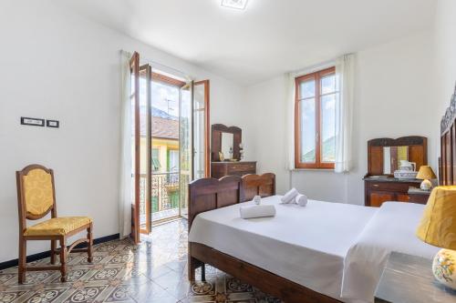 a bedroom with a large bed and a chair at Hostdomus-Country House in Orco Feglino