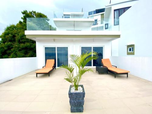 a patio with two chairs and a potted plant at Lalaguna Villas Luxury Dive Resort and Spa in Puerto Galera
