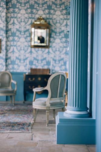 une pièce avec une chaise, une colonne et un miroir dans l'établissement 16th century Norman Manor, à Troarn