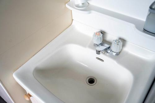 a white bathroom sink with two knobs on it at Silk Court 403 in Chitose
