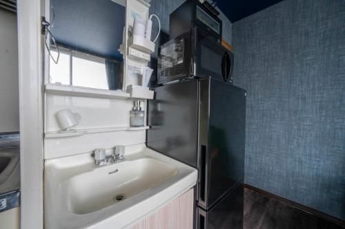 a small kitchen with a sink and a refrigerator at Silk Court 403 in Chitose