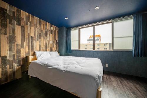 a bedroom with a bed and a window at Silk Court 403 in Chitose