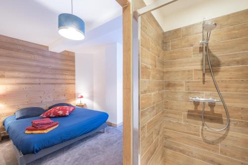 - une chambre avec une douche et un lit avec des draps bleus dans l'établissement Alpe One 1850 M - 8P-50 m d'une piste et centre - Sea and Mountain Pleasure, à L'Alpe-d'Huez