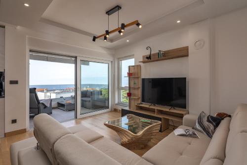 a living room with a large couch and a television at Seaview Apartment Kostrena Two - Happy Rentals in Kostrena