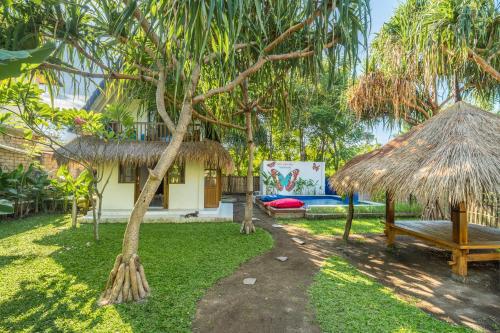 ein Garten mit einer Bank und einer Hütte in der Unterkunft Villa Kupu-Kupu, private pool & lush garden in Gili Air